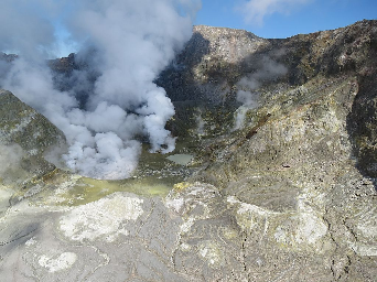 White Island showing a wide view of the active crater area. The lava dome is at the base of the prominent steam plume on the right side. The larger steam plume on the left side comes from a hot lake.