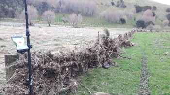 Debris stuck to farm fence after dam failure and draining of the lake. Kaiwhata River area. Photo: Brenda Rosser - GNS Science