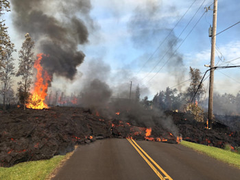 Lava from the 7th fissure to open threatened roads, electric infrastructure, and houses. The flow burns a power line and pole and he heat has also begun igniting trees in the area, leading to decreased air quality. (Photo courtesy of HVO/USGS). 