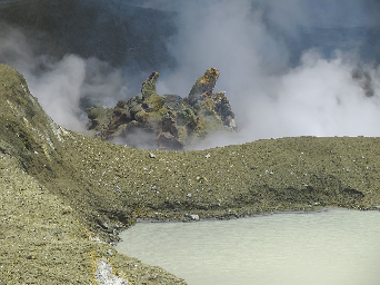 A close up view of the dome. The dome is made of thick, relatively cool and congealed lava and has prominent spines. The dome is about 20 – 30 metres across. In the foregrouond is a small, cold lake.