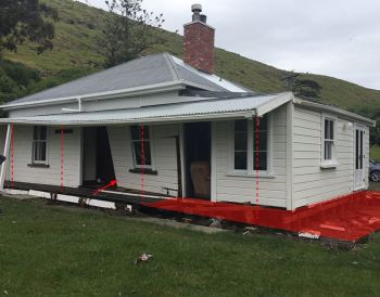Tsunami damage to the cottage at Little Pigeon Bay. The red area and lines are where the veranda and poles were. Photo: Penny Aitken