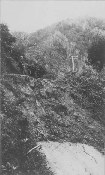 The White Creek Fault Scarp cutting across a road in the Buller Gorge with Horace Fyffe, Geological Survey geologist, undertaking his post-event survey by bicycle. . GNS Science