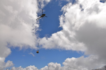 Helicopter carrying the temporary monitoring station into place