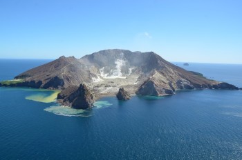 Aerial view of Whakaari/White Island, 4 October 2023 showing active steam and gas plumes from the main vent area (centre) and rock fall from Troup Head (centre left). Photograph credit: Brad Scott, GNS Science.