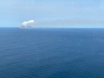 The vivid white steam and gas plume above the volcano