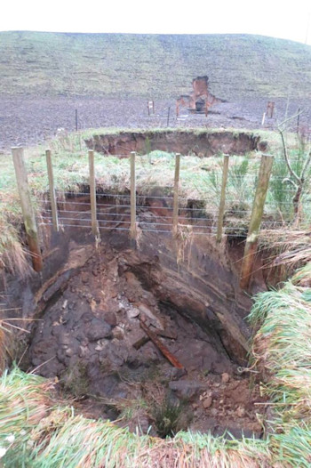 View into collapse hole at road edge on west side